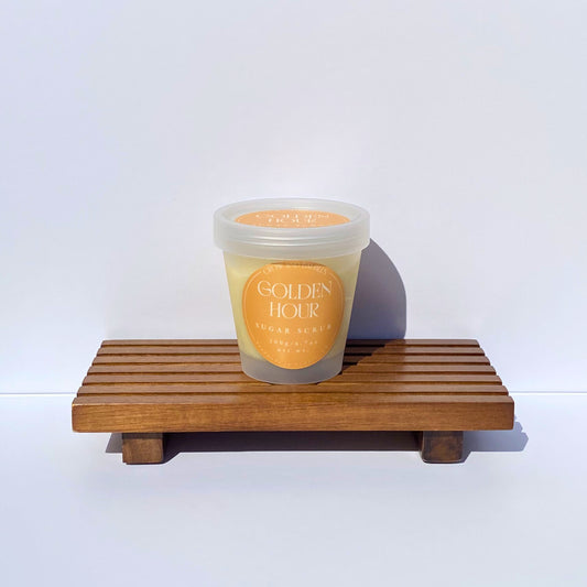 Clear sugar scrub container labeled "Golden Hour" on a white background