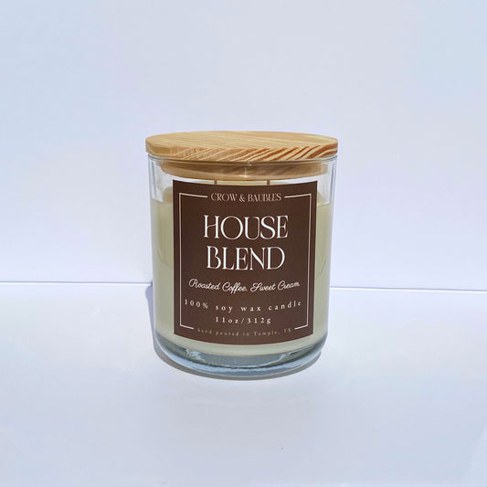 Candle with a wooden lid and brown label "House blend" on a white background