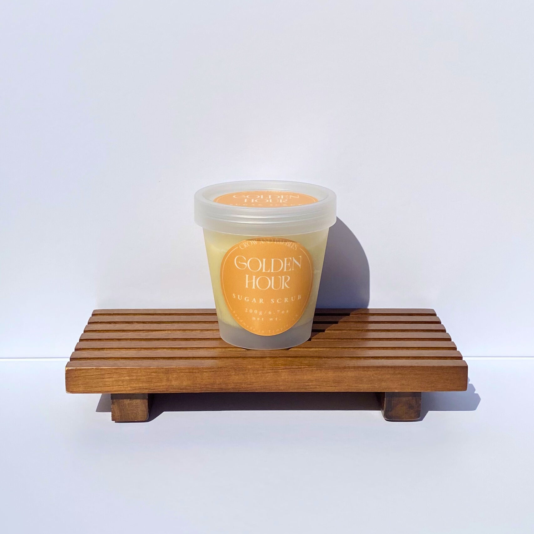 Clear sugar scrub container labeled "Golden Hour" on a white background