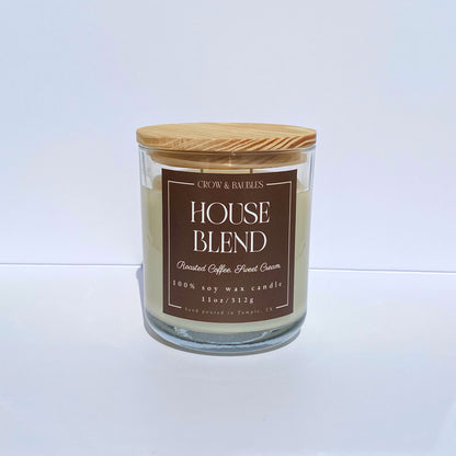 Candle with a wooden lid and brown label "House blend" on a white background