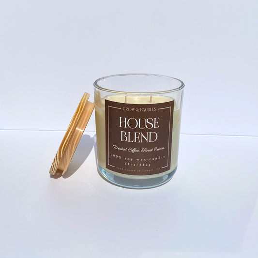 Glass candle with a wooden lid and brown label "House Blend" on a white background