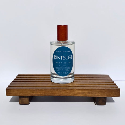 Bottle of Kintsugi on a wooden stand with a white background