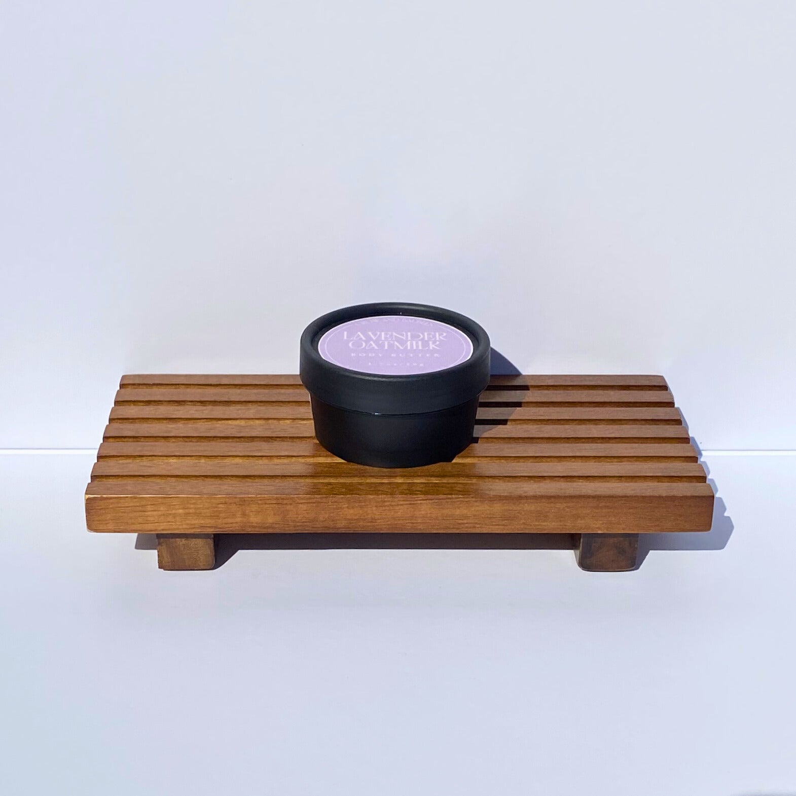 Wooden tray with a black container on a white background
