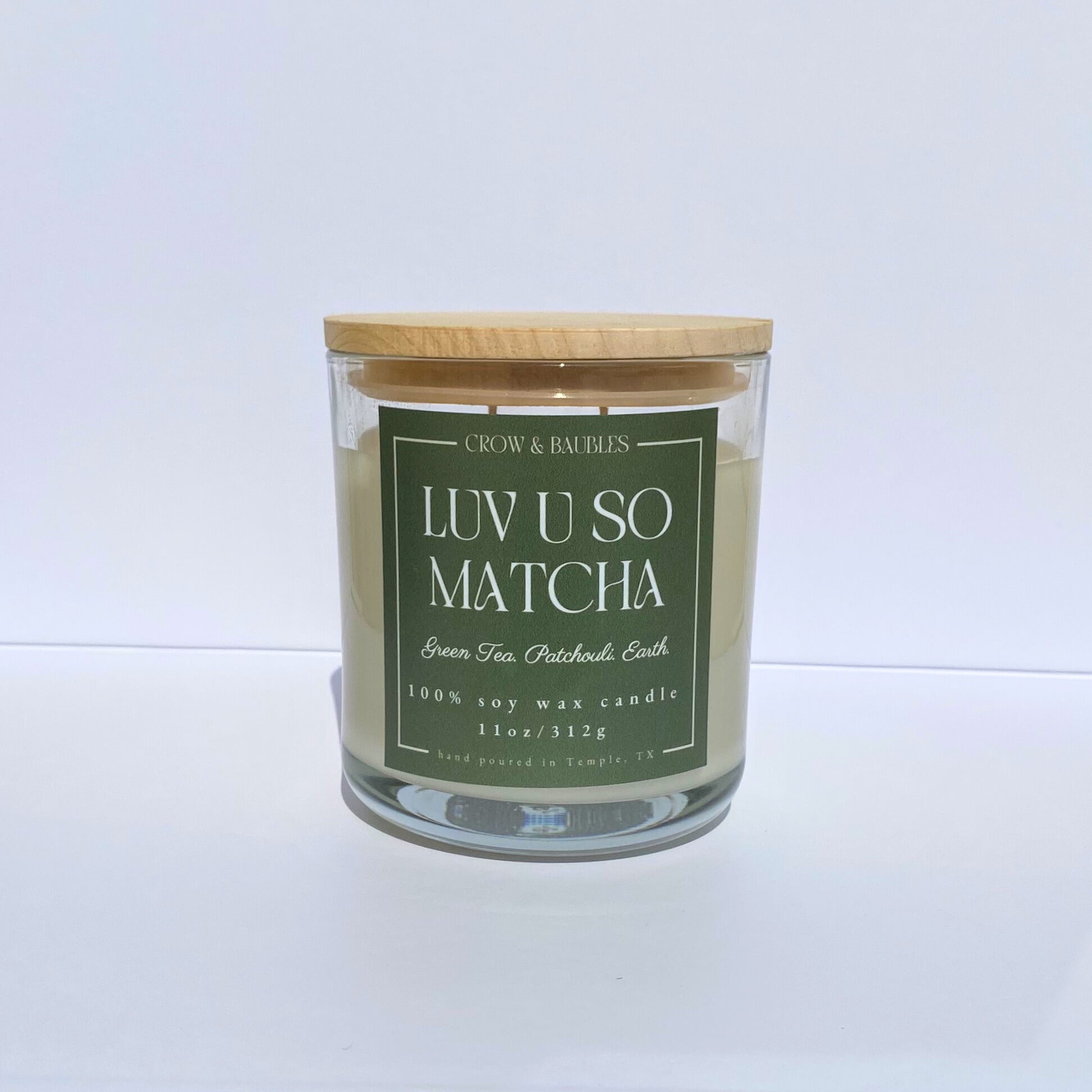 Matcha green tea candle with a wooden lid on a white background
