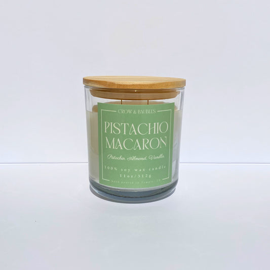 Candle with a green label "Pistachio Macaron" on a white background