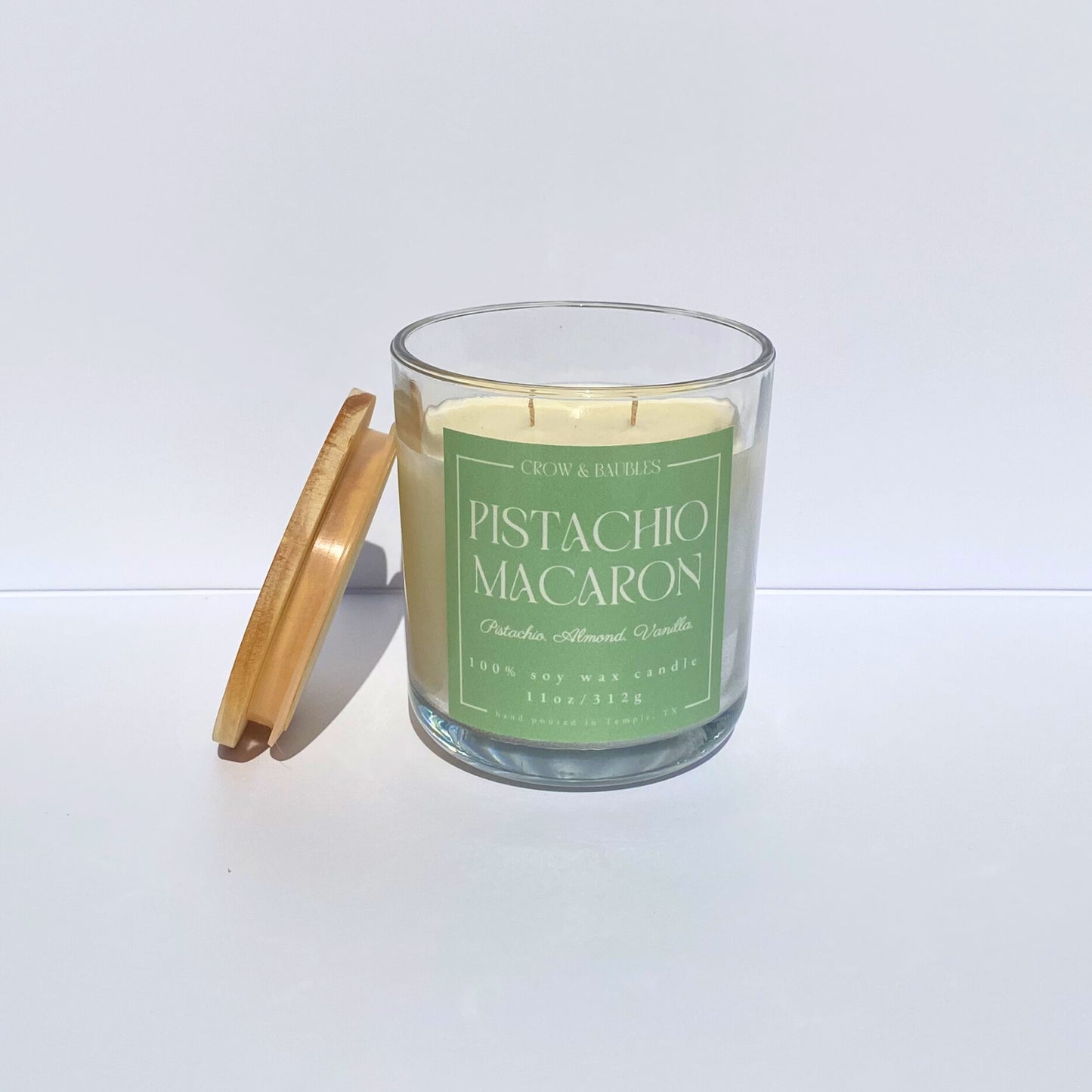 Pistachio Macaron candle with a wooden lid on a white background
