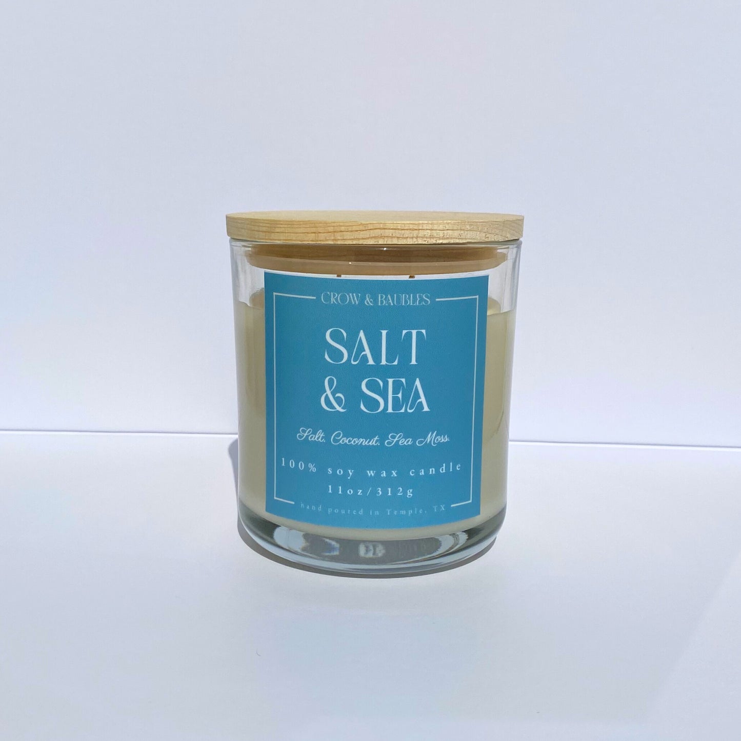 Candle with a blue label "salt & sea" on a white background