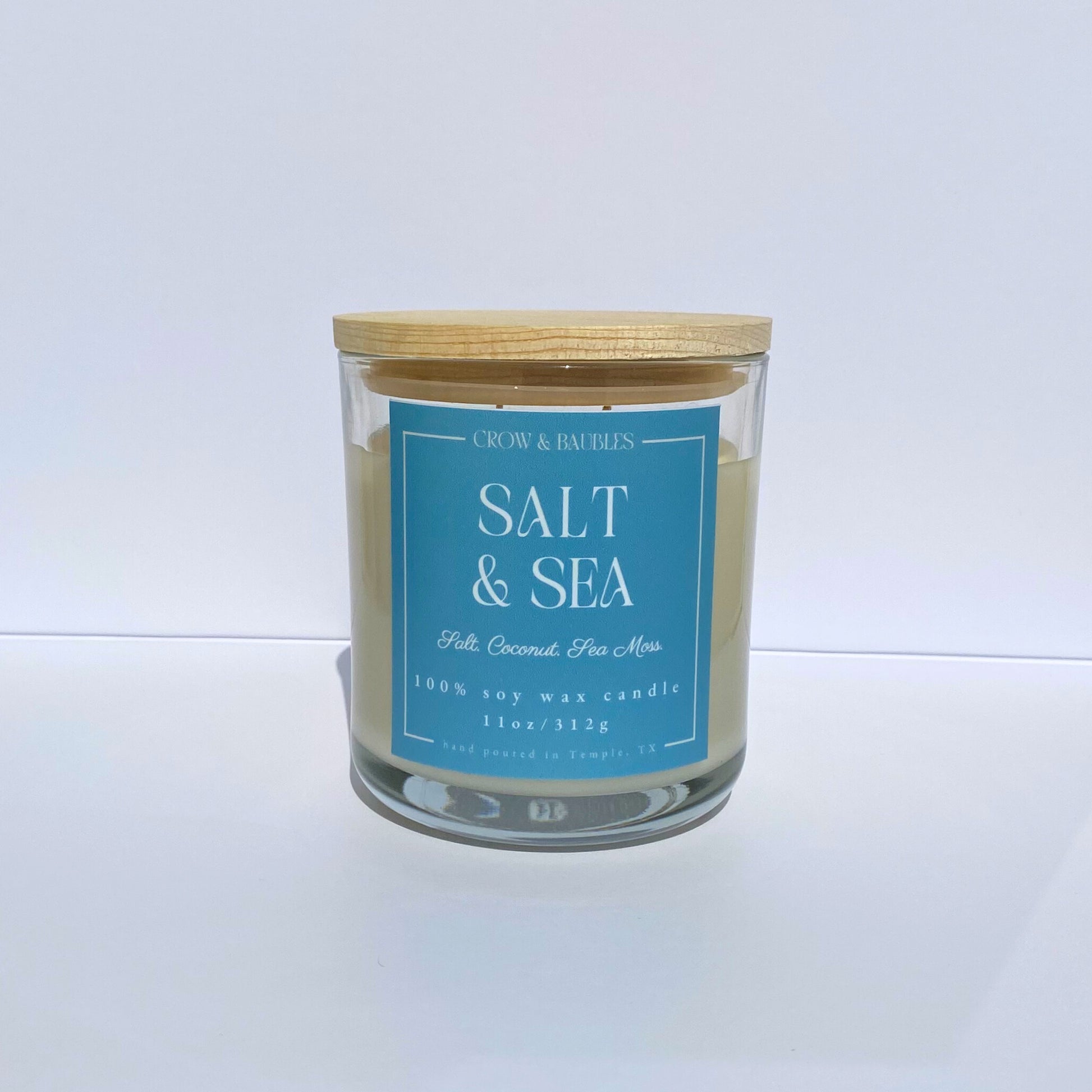 Candle with a blue label "salt & sea" on a white background