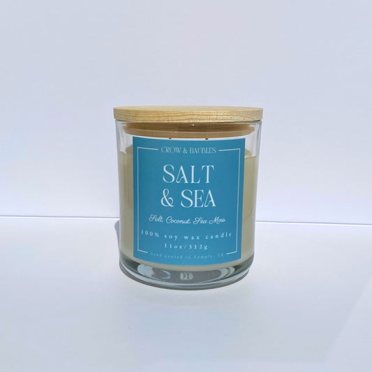 Candle with a blue label "salt & sea" on a white background