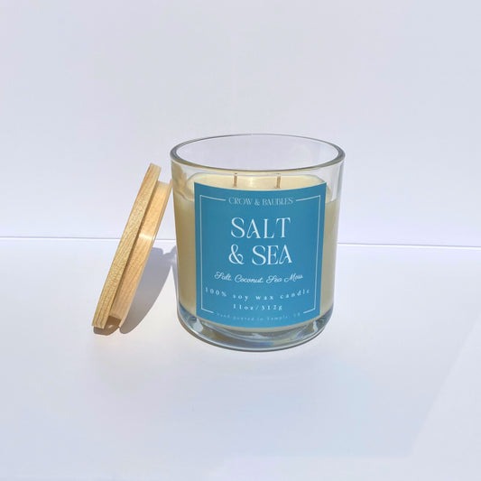Candle with a blue label reading 'Salt & Sea' on a white background